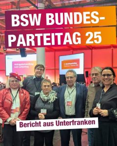 Gruppenfoto von sechs Teilnehmenden in einer Veranstaltungshalle beim BSW-Bundesparteitag; darüber die Grafik „BSW Bundesparteitag 25“, darunter „Bericht aus Unterfranken“. Im Hintergrund Bühne und Leinwände.